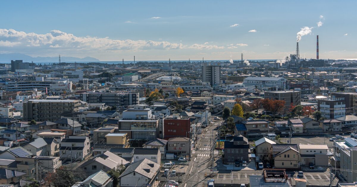 市街地と工場地帯が広がる海沿いの都市風景