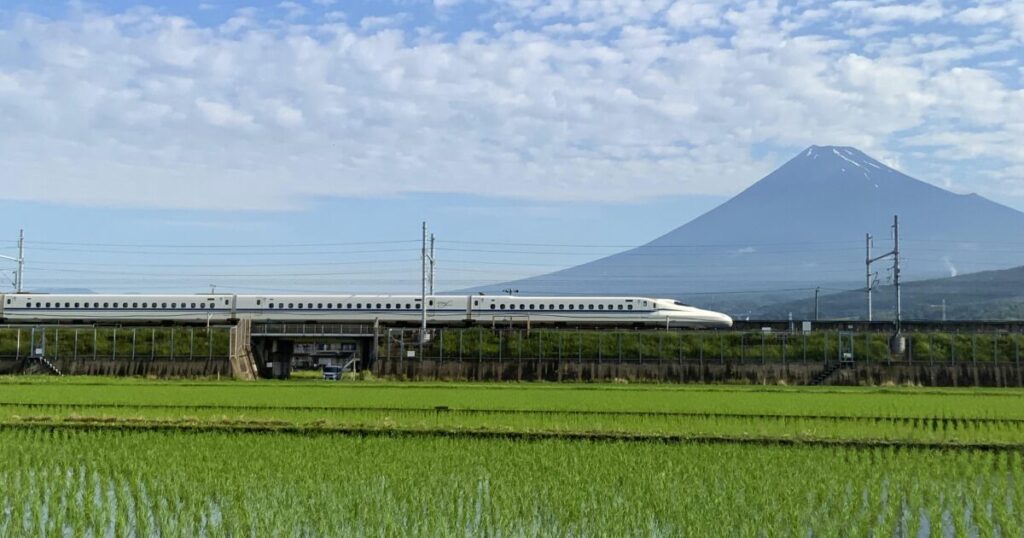 富士山を背景に新幹線が走る田園風景