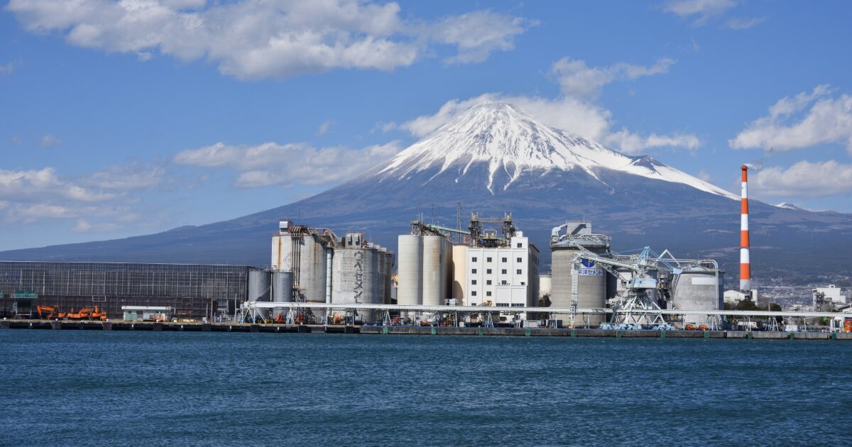 富士山と工場が立ち並ぶ港湾エリアの風景