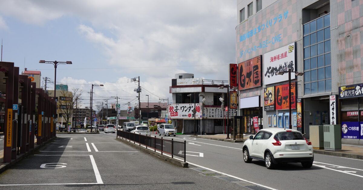 地方都市の商業エリアと車が走る街並み