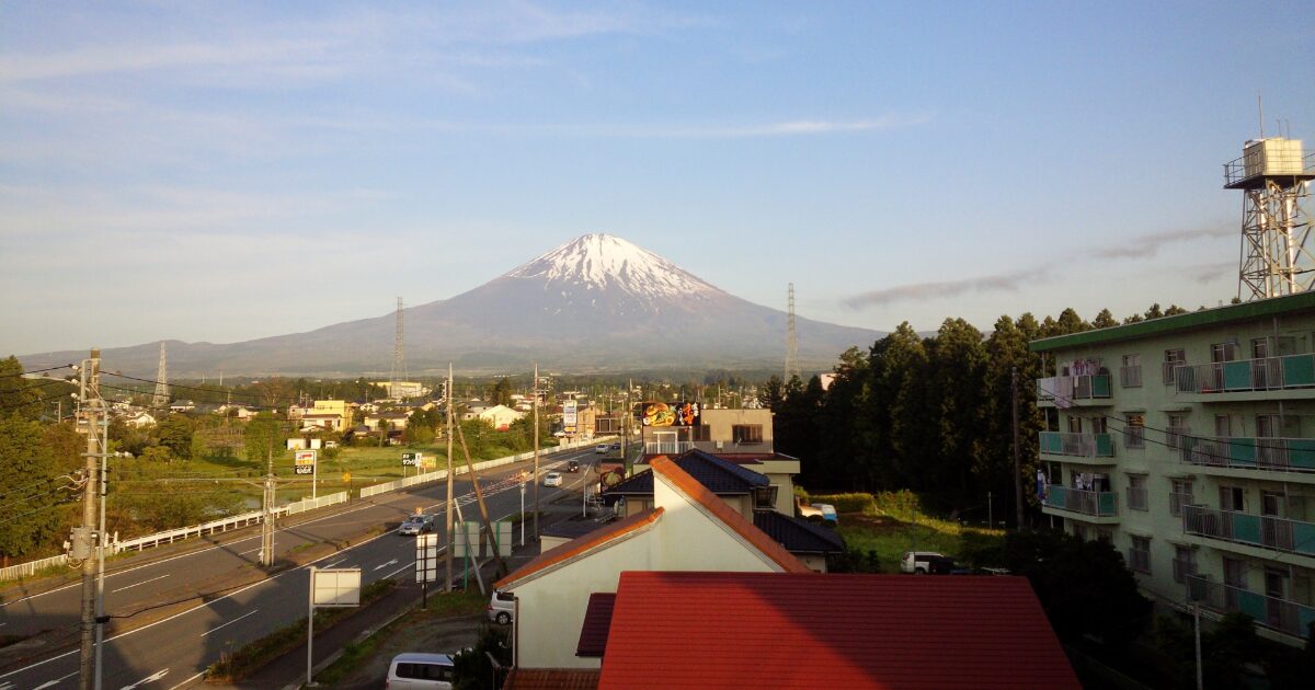 住宅街と道路越しに望む晴天の富士山