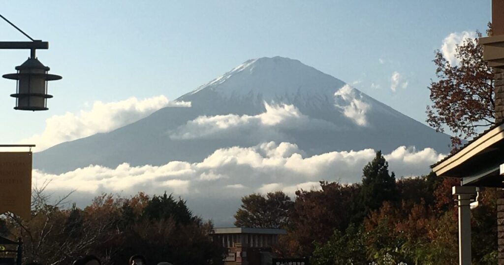 雲に囲まれた富士山と秋の街並み風景