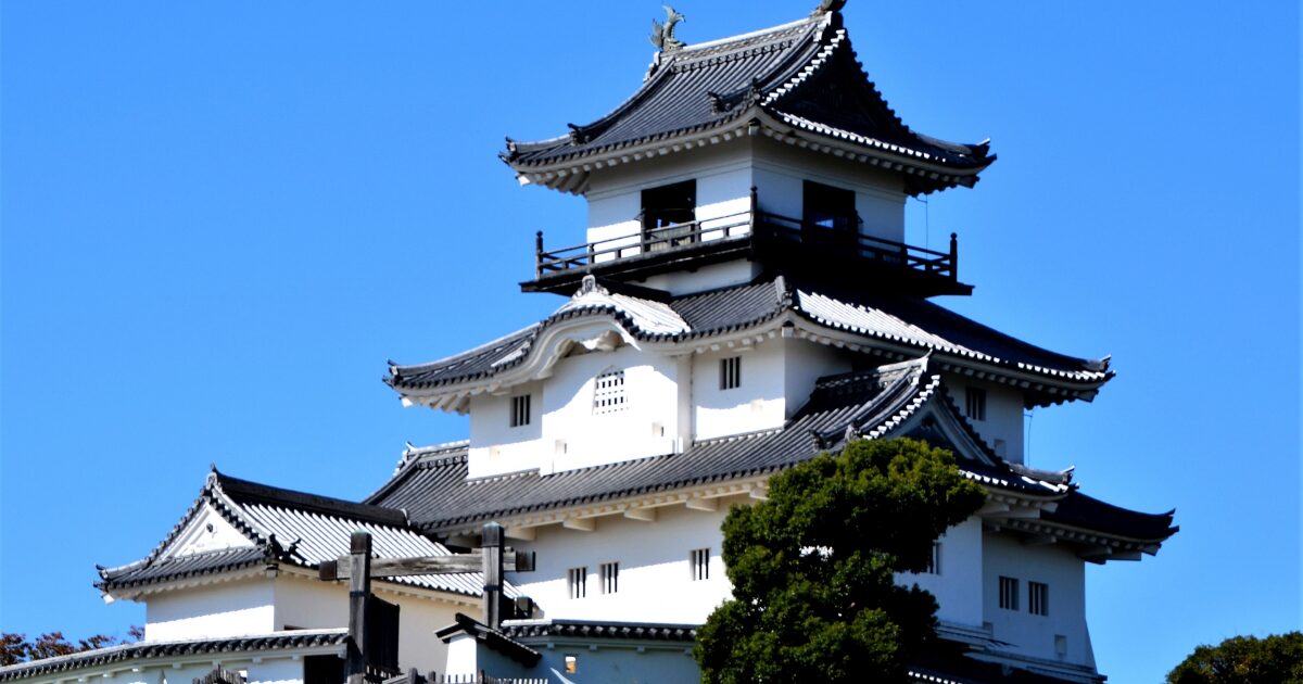 青空の下にそびえる白壁の天守閣を捉えた城の外観