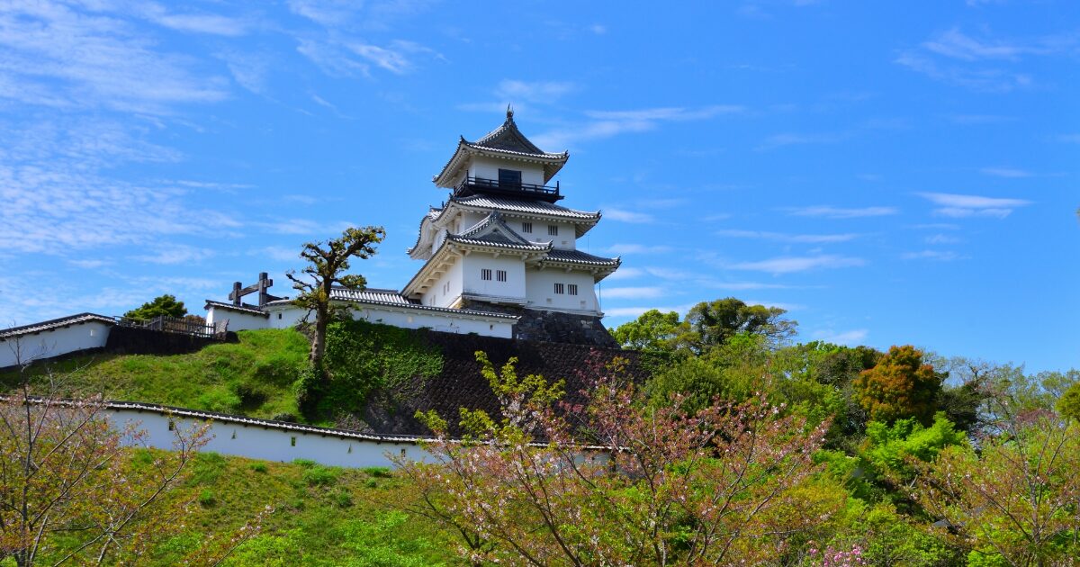 緑と桜に囲まれた丘の上の日本の城と春の景観