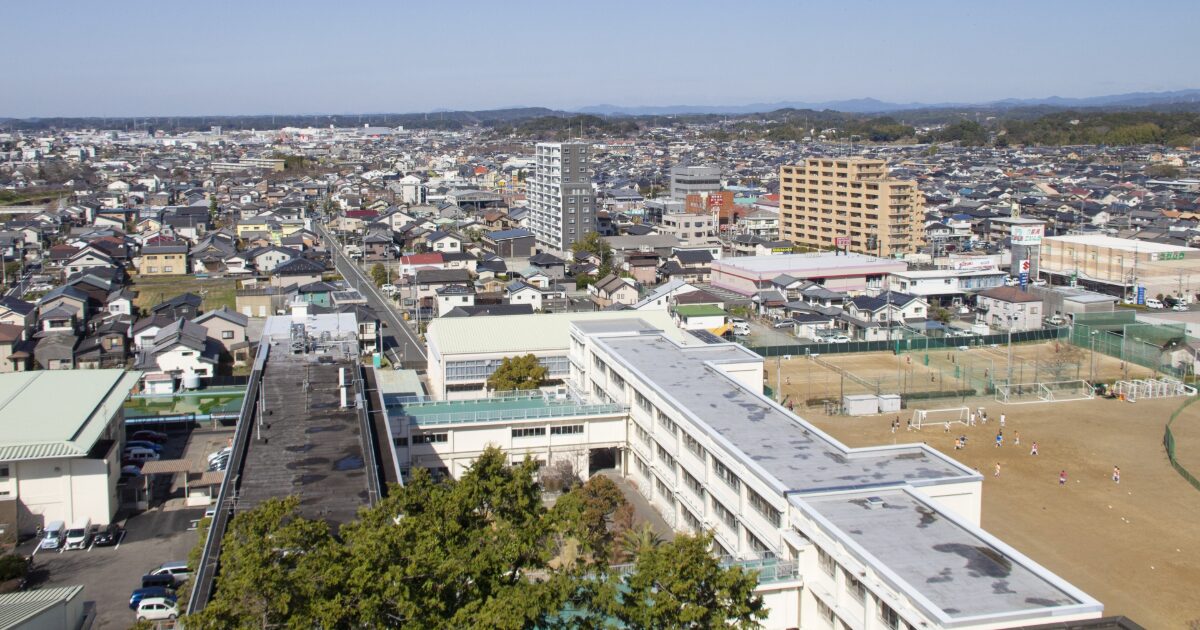 学校校舎と校庭を上空から撮影した住宅街の風景