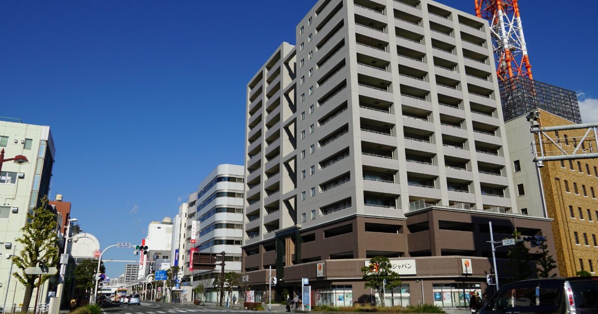 高層マンションと電波塔がそびえる都市の街並み