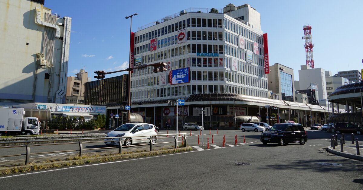 商業施設ラクーン前の交差点と車が行き交う都市風景