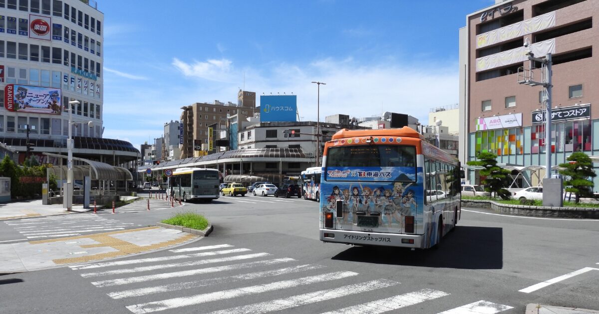 駅前ロータリーを走るバスと商業施設の街並み