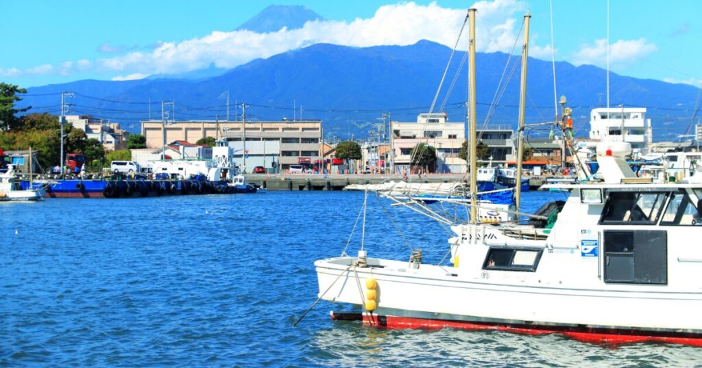 港に停泊する船と富士山を望む風景