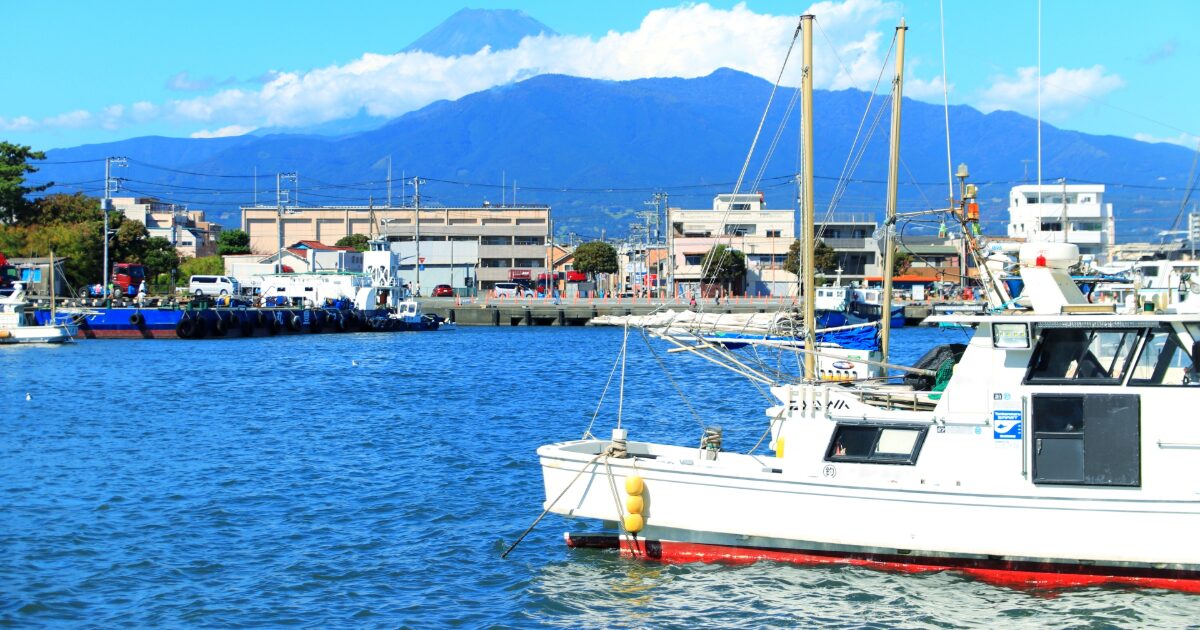 港に停泊する船と富士山を望む風景