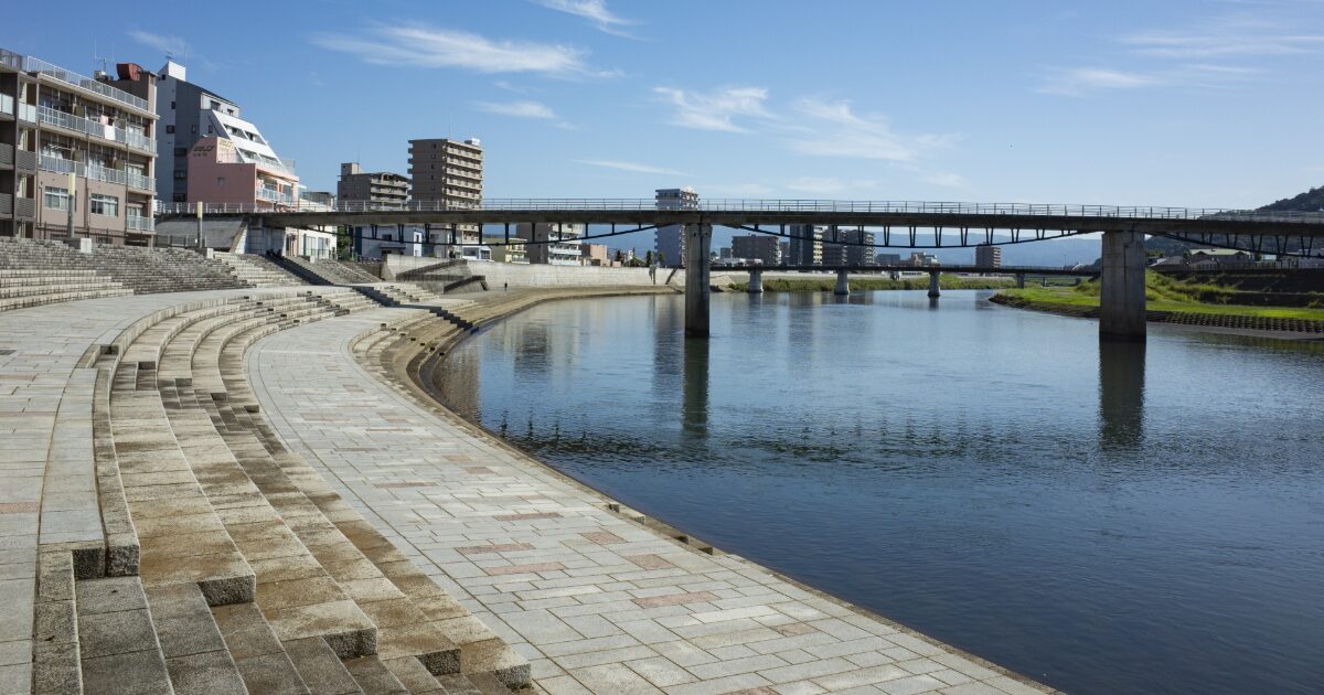 川沿いの遊歩道と橋が続く穏やかな景観