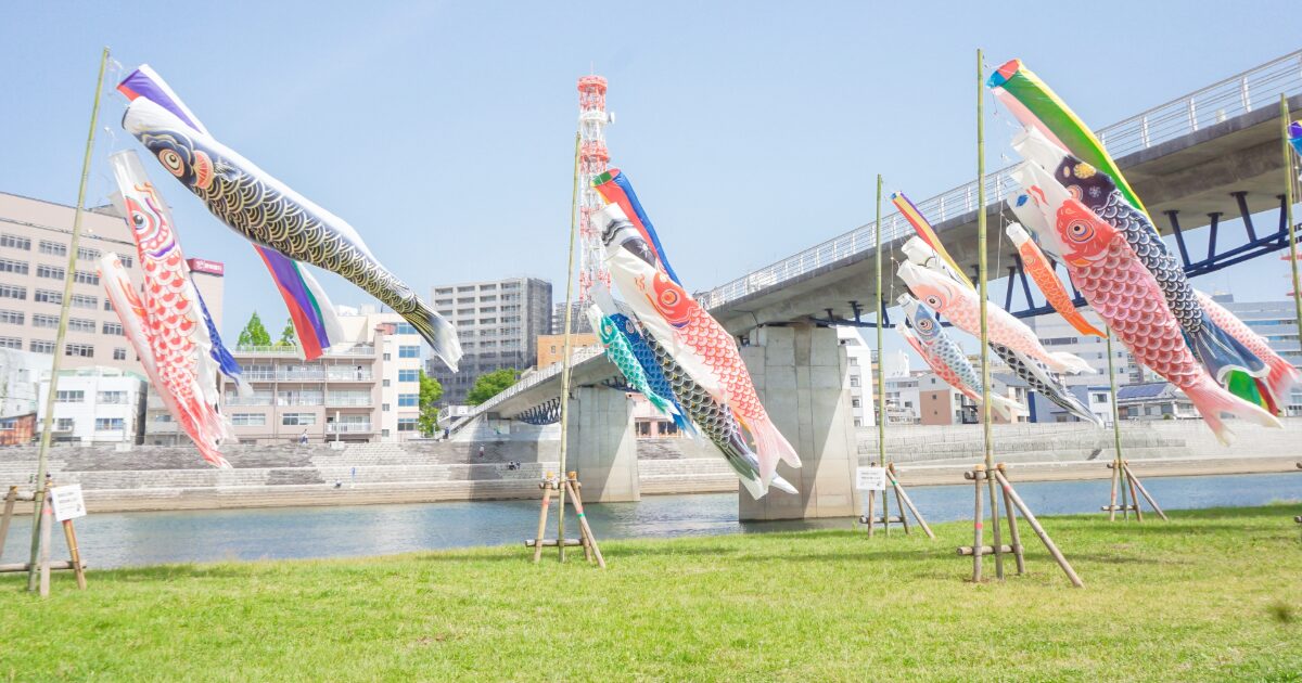 川沿いに泳ぐ鯉のぼりと橋の風景