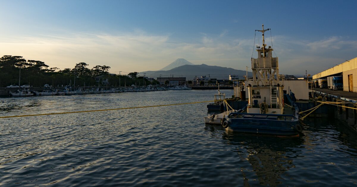 港に停泊する船と夕景の富士山
