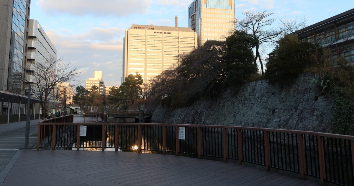 川沿いの遊歩道と石垣に囲まれた水辺の落ち着いた景観