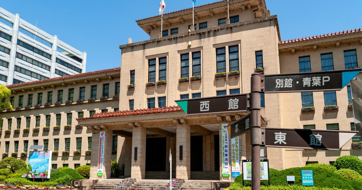 庁舎前の案内標識と歴史的建築が並ぶ公共施設の外観