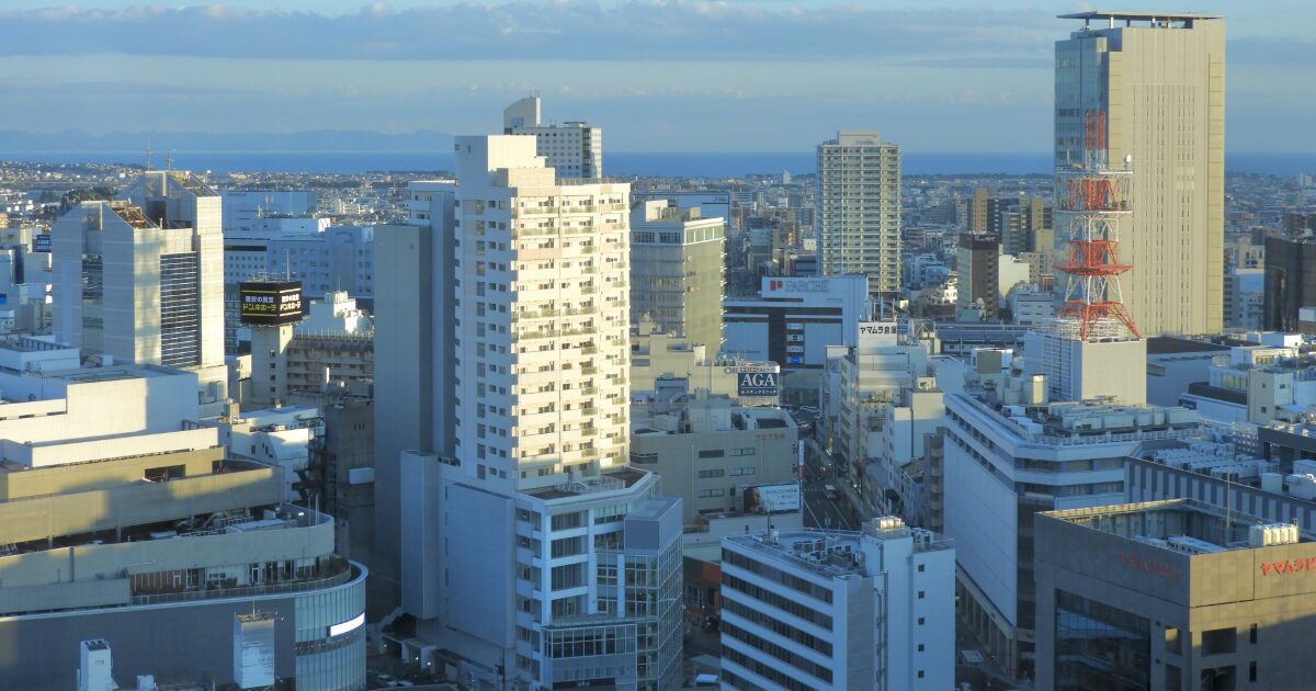 高層ビルが立ち並ぶ都市中心部と遠くに見える海の景色
