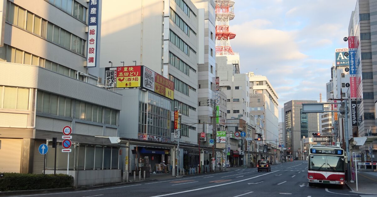 バスが走る市街地の道路とビルが並ぶ都市風景
