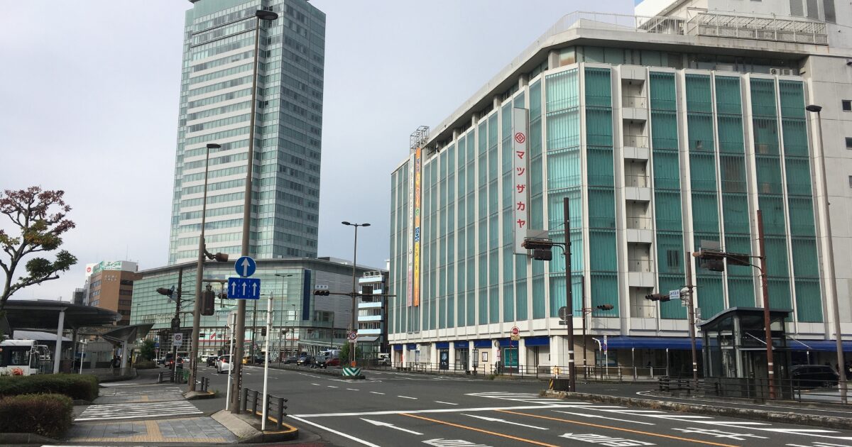 ガラス張りの商業ビルと交差点がある都市の街並み