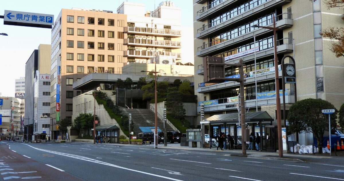 バス停とオフィスビルが並ぶ市街地の通りの風景